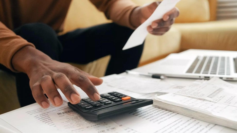 Person using a calculator to determine cost
