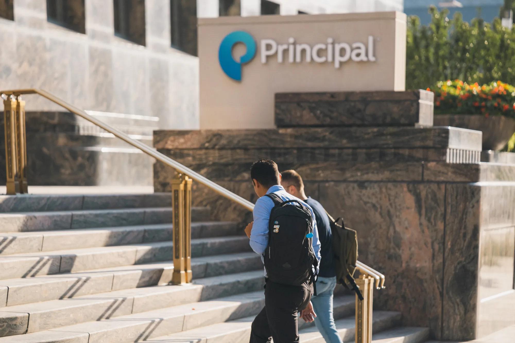 Two employees walking into a Principal headquarters building. Two employees walking into a Principal headquarters building.