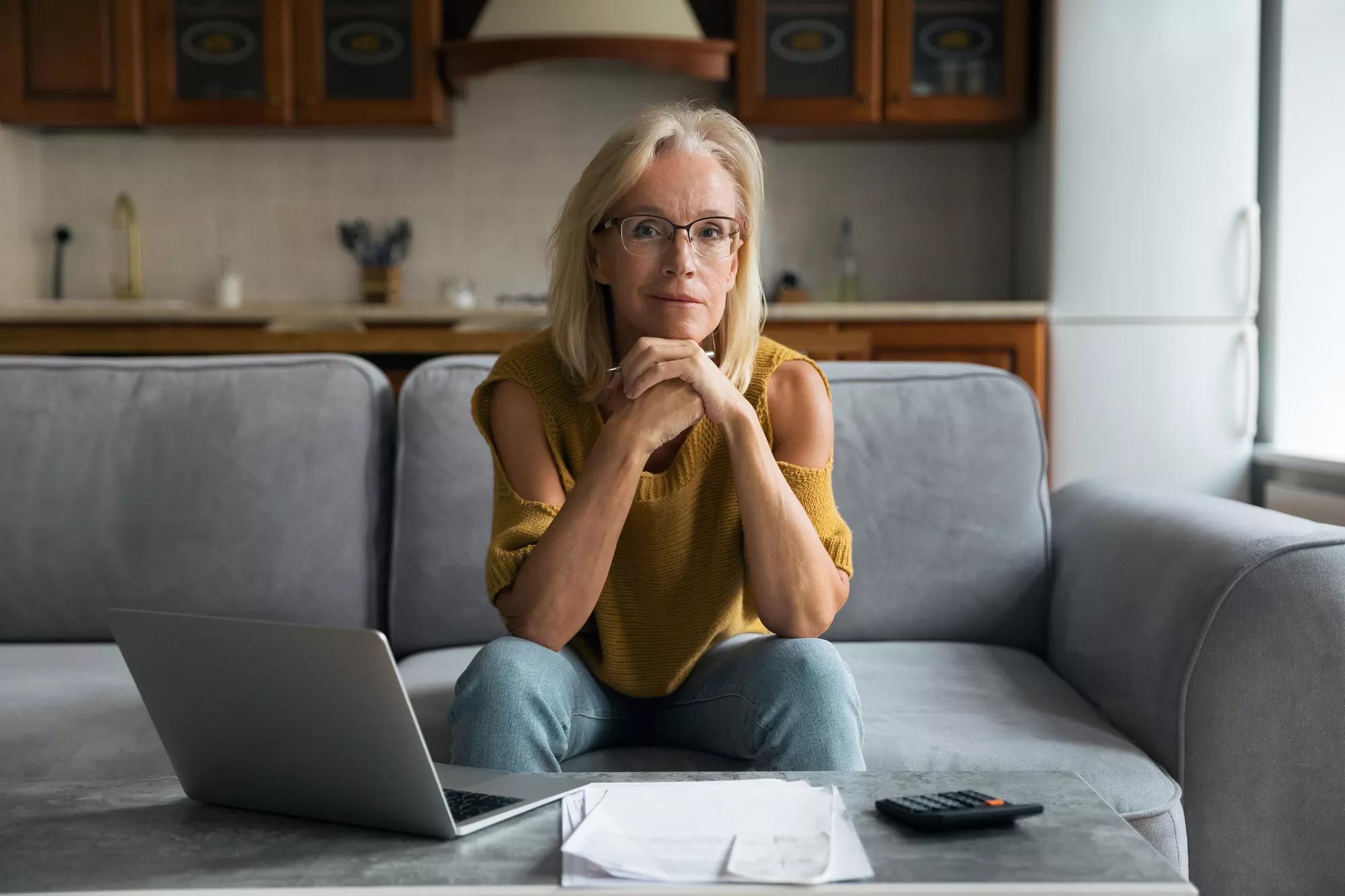 Older white woman on the couch working at her laptop. Older white woman on the couch working at her laptop.