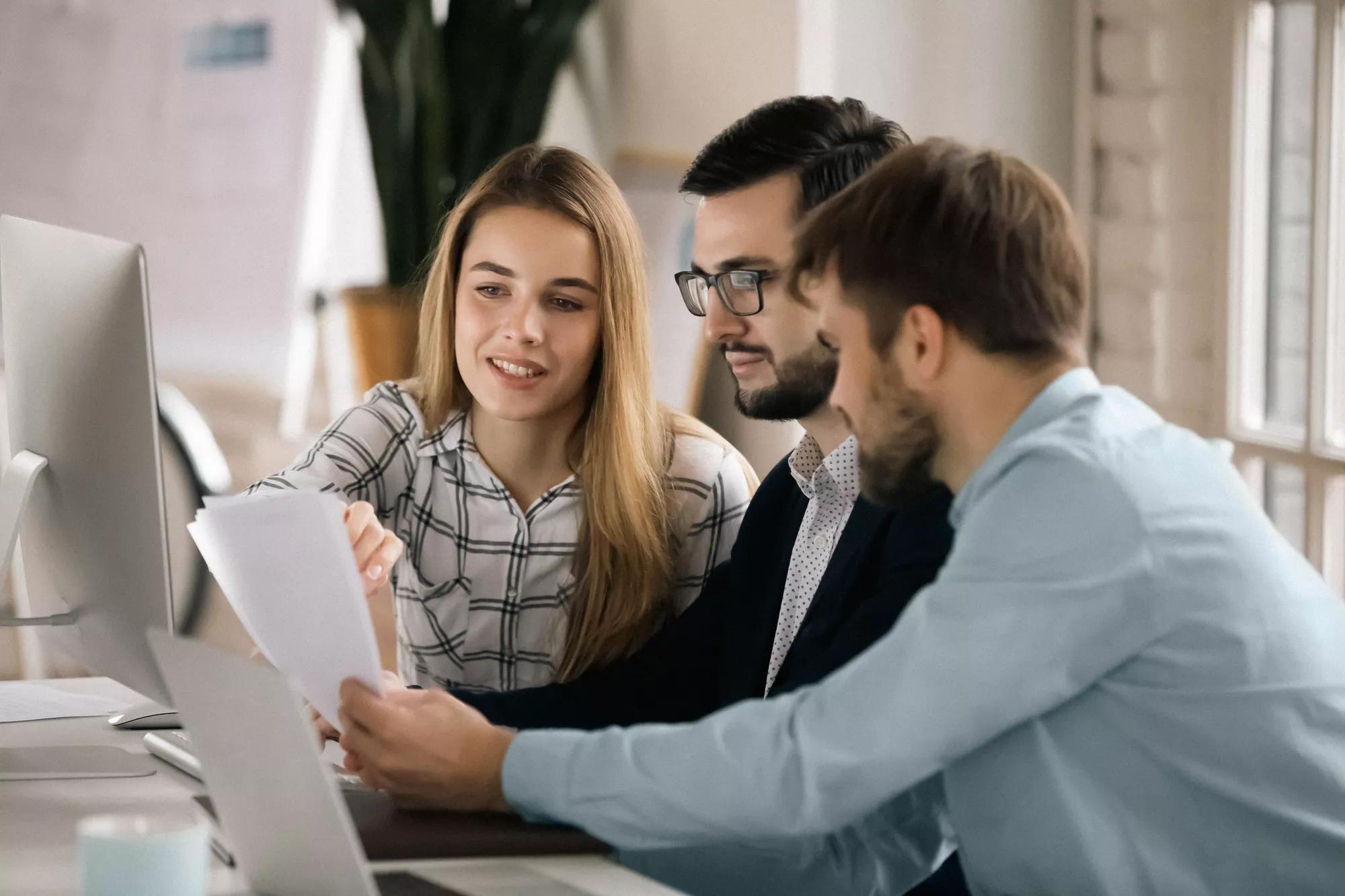 Colleagues discuss company financial paperwork together. Colleagues discuss company financial paperwork together.