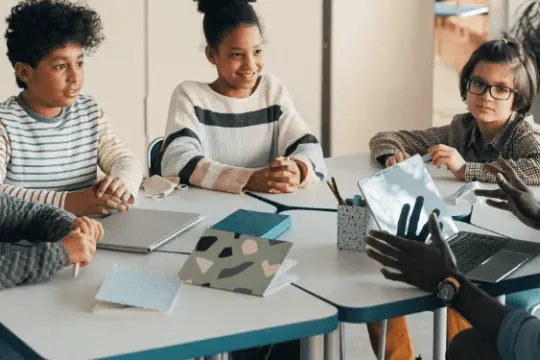 Photo of a man with a laptop teaching children what a bond is.