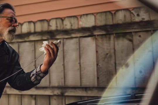 Un hombre revisando el aceite de su vehículo