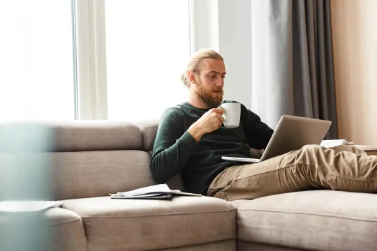 Man sitting on couch looking at computer