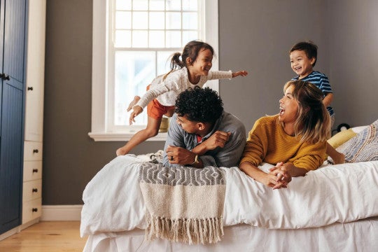 Un padre, una madre y sus dos hijos jugando juntos.