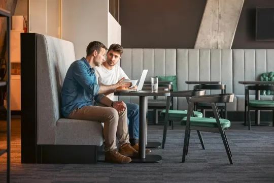 Two adult men looking at a computer