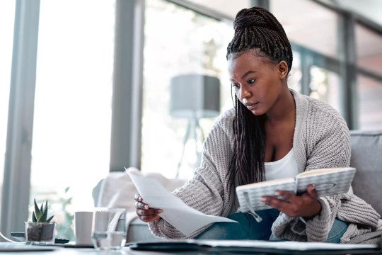 Woman sitting together on a couch working on their budget on a computer