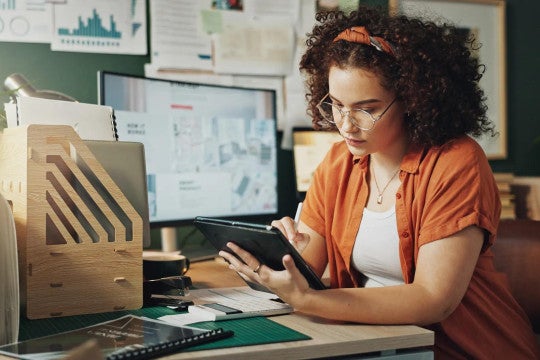 Woman working on tablet to review her finances