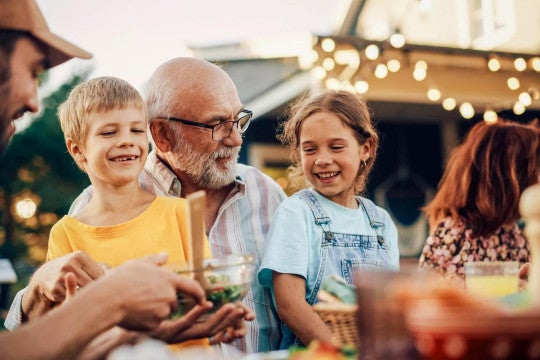 A grandfather enjoys dinner and spending time with his family