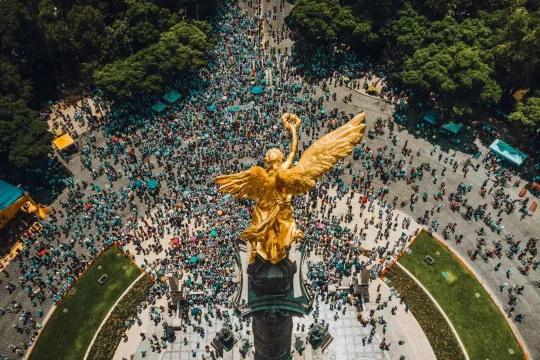 High angle view of crowd gathering around El Ángel in Mexico City.