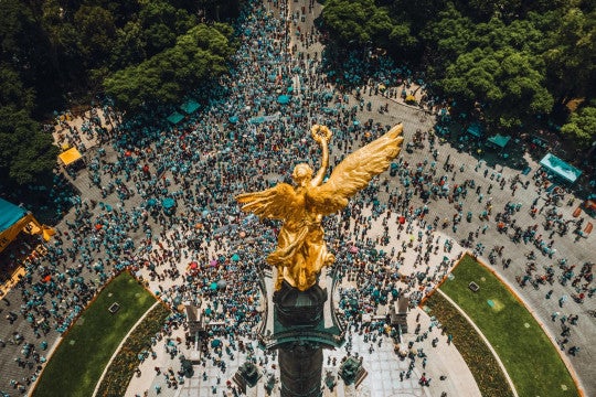 High angle view of crowd gathering around El Ángel in Mexico City.