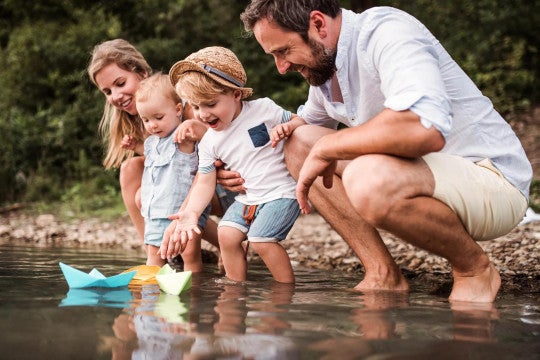 Parents and two toddlers playing in water.