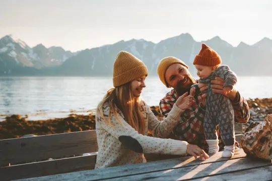 Mom and dad with young child sitting outside.