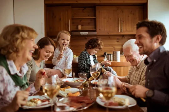 A happy family eating around a table.