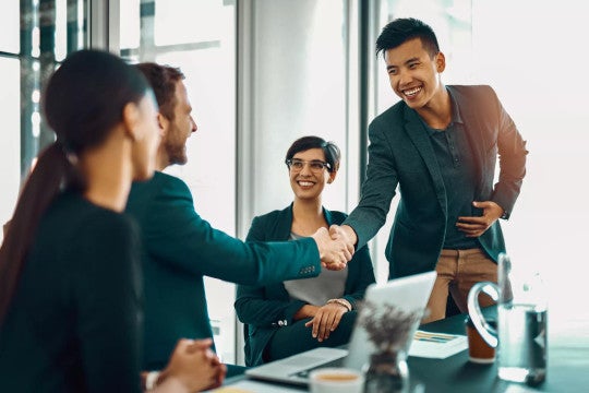 Man shaking hands with co-worker during a new job meeting