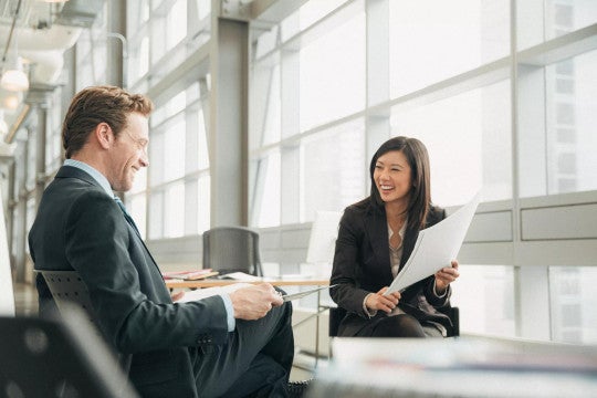 Two business people smiling as they review their defined benefits strategy