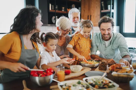 Family gathered around a kitchen island filled with food