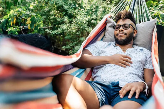 A man lounging in a hammock.