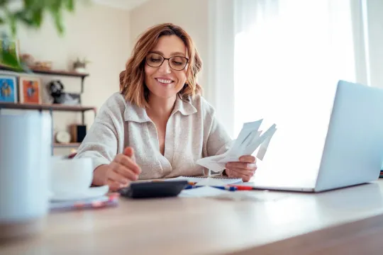 A woman reviewing her finances to make financial trade-offs