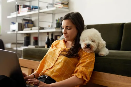 A woman sitting with her dog reviewing her retirement account