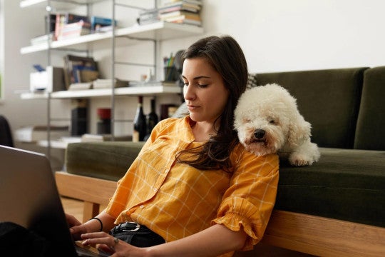 A woman sitting with her dog reviewing her retirement account