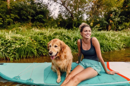 A woman sitting outside with her dog.