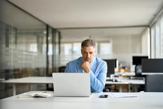 A man sits at his computer trying to stay up to date with tarrifs