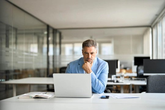 Business executive reading news on a computer