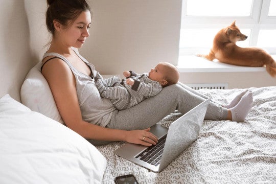 A mother sitting on the bed with her child in her lap