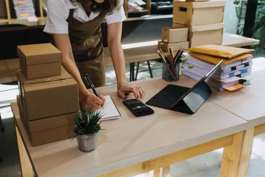 A person writing on a notepad in a retail setting.
