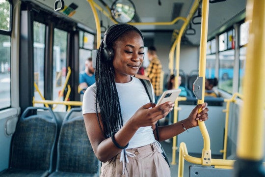 Young woman on city bus looking on her phone