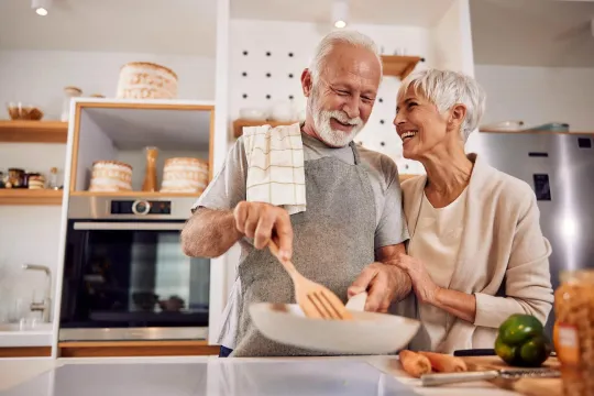 Older man and woman in kitchen making a meal