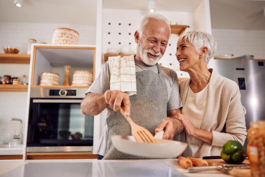 Older man and woman in kitchen making a meal