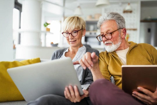 Retired man and woman looking at a computer