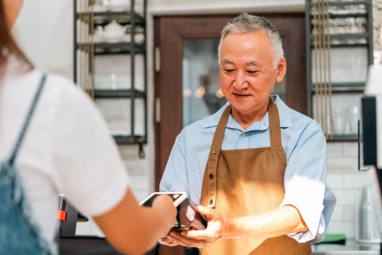 A cashier for a small business receives a digital payment from a customer. 