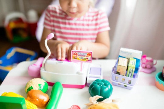 Child playing with a toy cash register