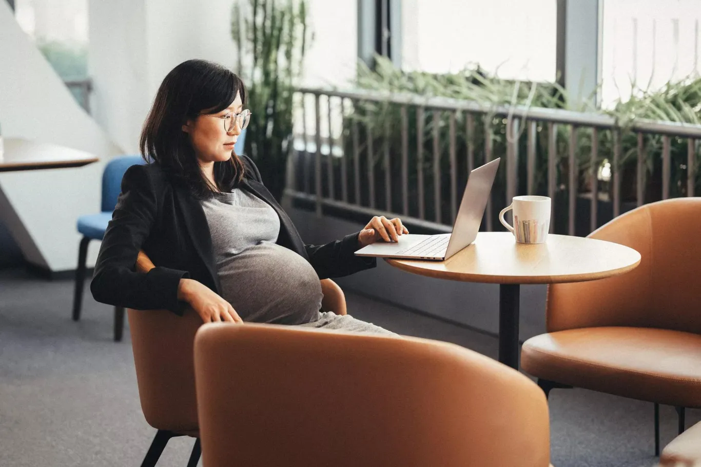 Pregnant woman sitting in front of computer.