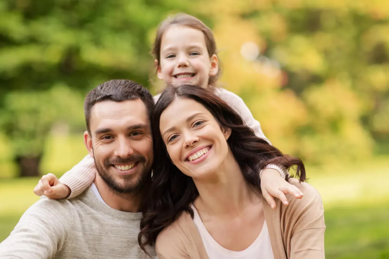 Husband, wife, and young daughter promoting dental care and affordable dental insurance plans.