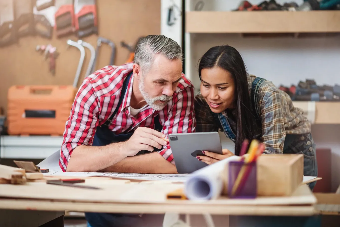 A man and woman looking at an iPad together.