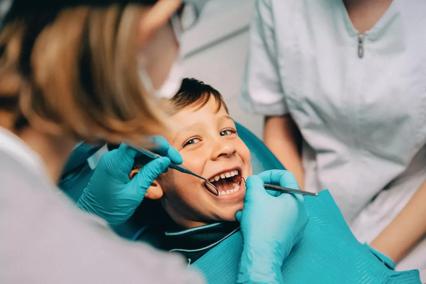 A young boy having a dental care exam at the dentist office.