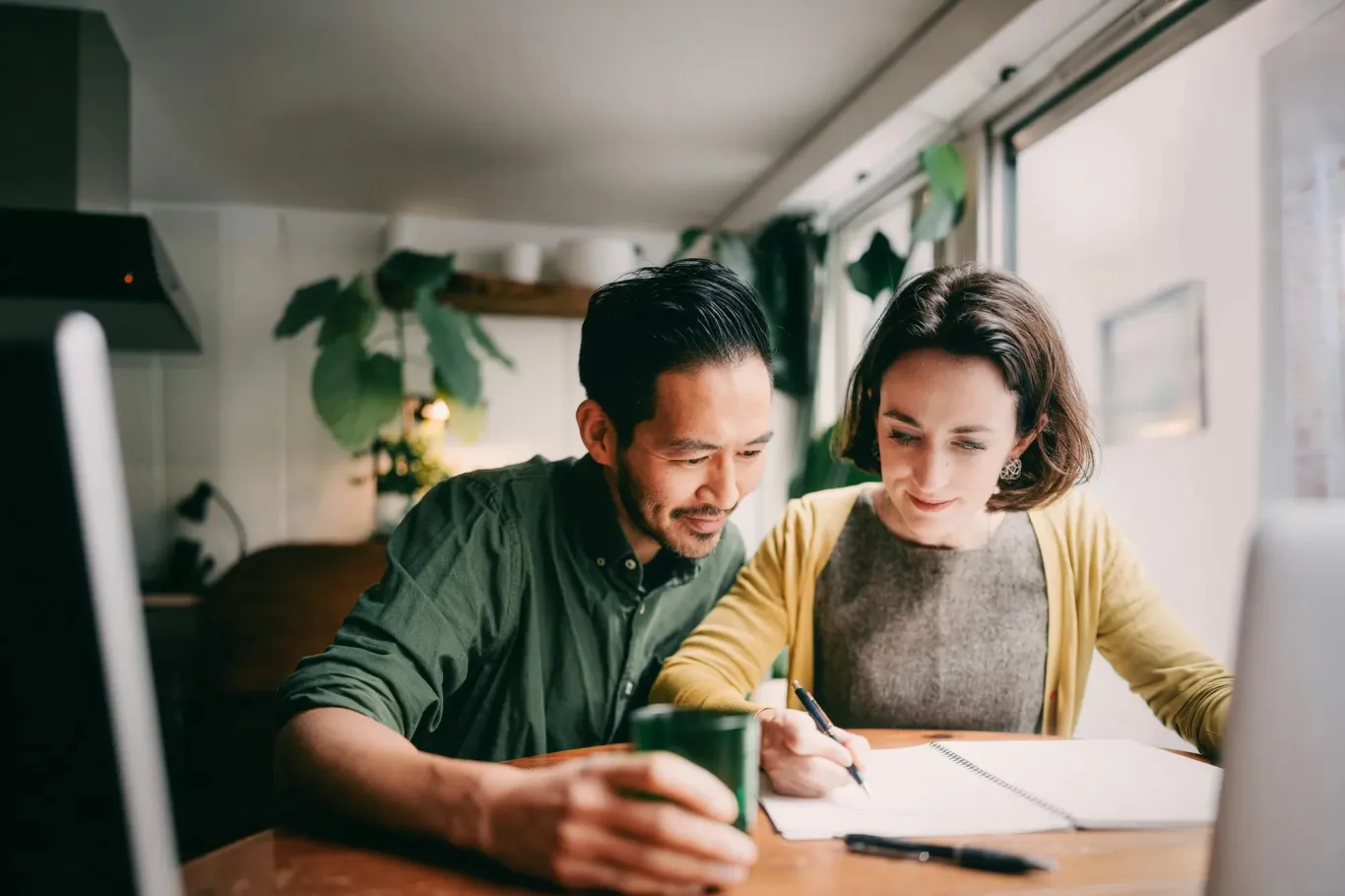 Two people seated together at a wooden table.