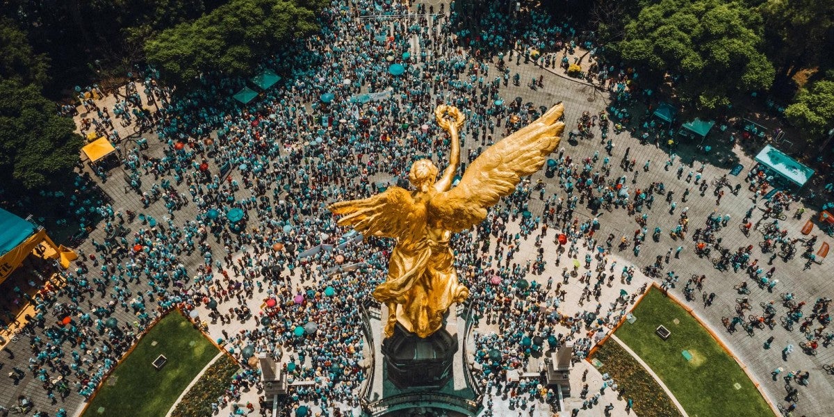 High angle view of crowd gathering around El Ángel in Mexico City.