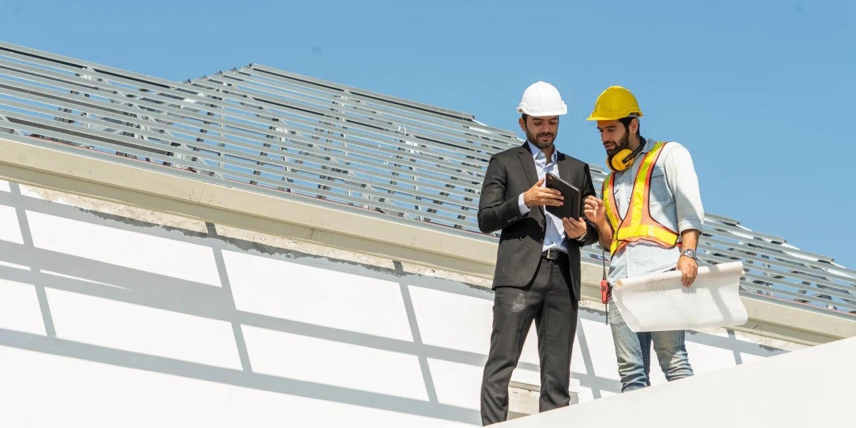 A business owner and employee discuss a project at the worksite.