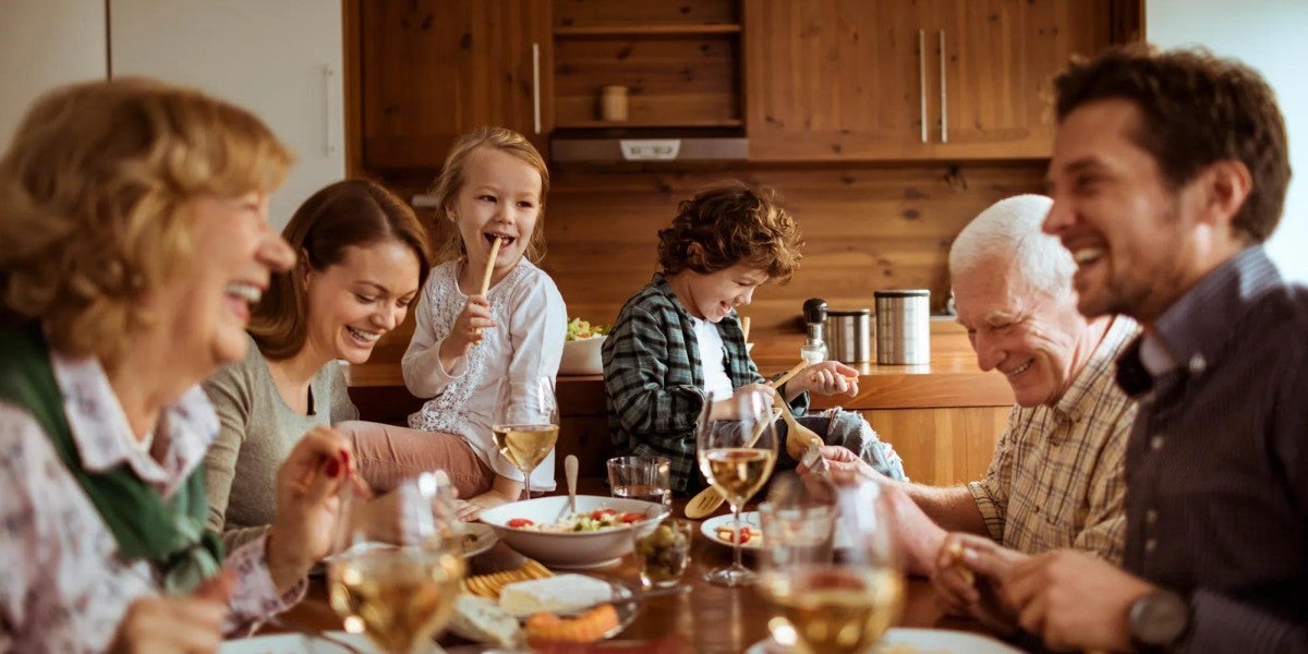 A happy family eating around a table.