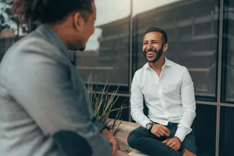 Man smiling in an active conversation.
