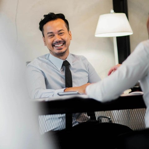 A TPA smiling as he helps co-workers.