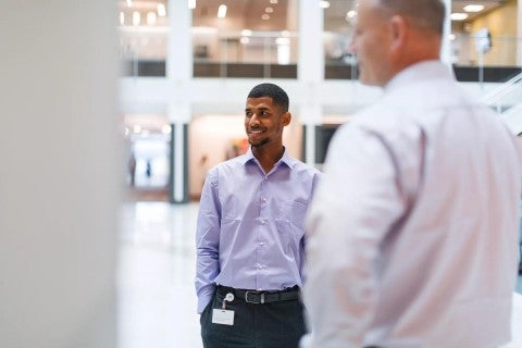 Two Principal employees talking at corporate headquarters.