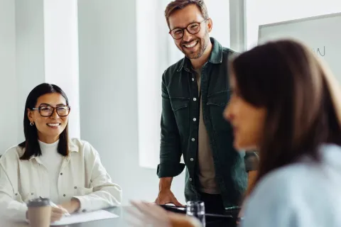A small group of employees smiling while working together.