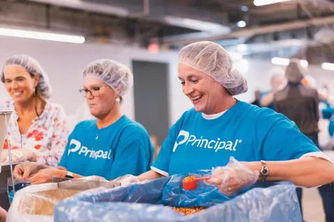 Principal volunteers packing meals for Meals for the Heartland.