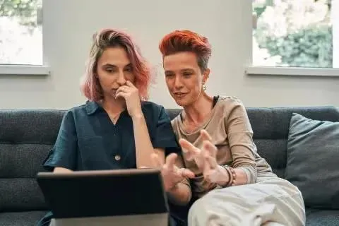 Two women looking at tablet.