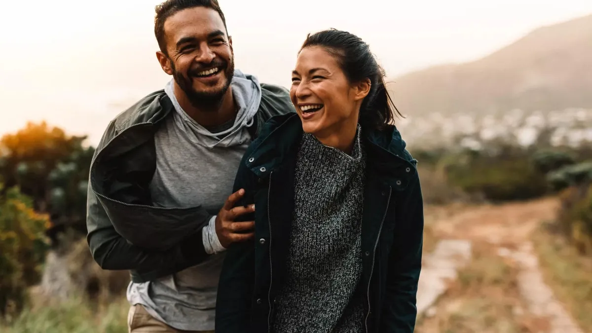 A happy young couple walking together outside.